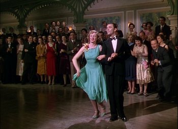 Movie still from “This Happy Breed” (1944), directed by David Lean – A man and a woman are dancing in front of a crowd; Wide shot, Low angle