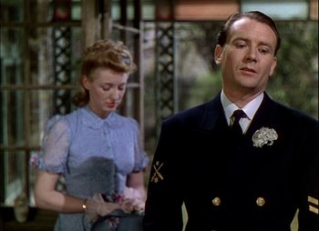 Movie still from “This Happy Breed” (1944), directed by David Lean – A man and a woman standing next to each other in front of a building; Close Up shot, Over the shoulder angle