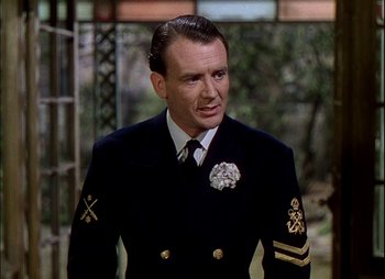 Movie still from “This Happy Breed” (1944), directed by David Lean – A person wearing a suit and tie; Close Up shot, Over the shoulder angle