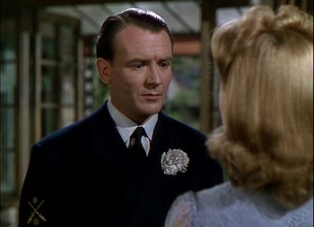 Movie still from “This Happy Breed” (1944), directed by David Lean – A person wearing a suit and tie; Close Up shot, Over the shoulder angle