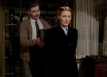 Movie still from “This Happy Breed” (1944), directed by David Lean – An older man and a younger woman standing next to each other; Medium shot, Low angle