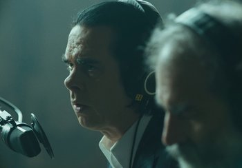 Movie still from “This Much I Know to Be True” (2022), directed by Andrew Dominik – A man with a microphone and ear phones on; Close Up shot, Over the shoulder angle
