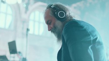 Movie still from “This Much I Know to Be True” (2022), directed by Andrew Dominik – A man with long white beard wearing headphones; Close Up shot, Low angle