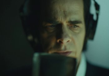 Movie still from “This Much I Know to Be True” (2022), directed by Andrew Dominik – A person wearing a headset; Close Up shot, Low angle