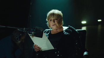 Movie still from “This Much I Know to Be True” (2022), directed by Andrew Dominik – An older woman is holding a sheet of paper; Close Up shot, Low angle