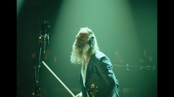 Movie still from “This Much I Know to Be True” (2022), directed by Andrew Dominik – A man with long white hair and a white beard is holding a violin; Medium shot, Low angle