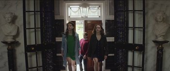 Movie still from “Thoroughbreds” (2017), directed by Cory Finley – Two women and a boy are walking down the hall way; Medium shot, Low angle