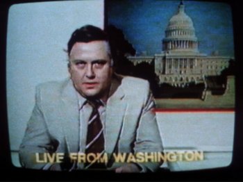 Movie still from “Threads” (1984), directed by Mick Jackson – A man wearing a suit and tie sitting in front of the capitol building; Close Up shot, Low angle