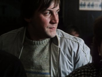 Movie still from “Threads” (1984), directed by Mick Jackson – A person wearing a jacket; Close Up shot, Over the shoulder angle