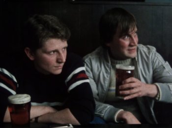 Movie still from “Threads” (1984), directed by Mick Jackson – Two men sitting next to each other at a bar; Medium shot, High angle