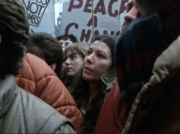 Movie still from “Threads” (1984), directed by Mick Jackson – A group of people holding up signs in a crowd; Close Up shot, High angle