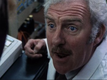 Movie still from “Threads” (1984), directed by Mick Jackson – An older man with white hair and blue eyes looking surprised; Close Up shot, Low angle