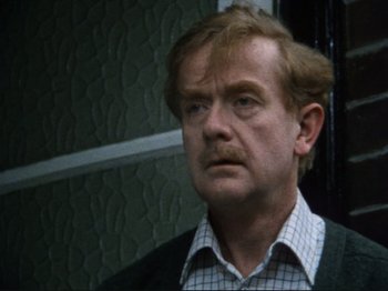 Movie still from “Threads” (1984), directed by Mick Jackson – A person wearing a shirt and tie; Close Up shot, High angle