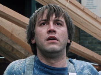 Movie still from “Threads” (1984), directed by Mick Jackson – A person wearing a blue shirt; Close Up shot, Low angle