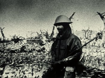 Movie still from “Threads” (1984), directed by Mick Jackson – An old photo of a man with a rifle in a field; Medium shot, Low angle