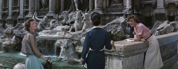 Movie still from “Three Coins in the Fountain” (1954), directed by Jean Negulesco – A woman standing in front of a fountain with statues; Wide shot, High angle