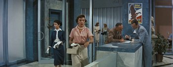 Movie still from “Three Coins in the Fountain” (1954), directed by Jean Negulesco – A group of people standing in a room; Medium shot, Low angle