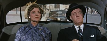 Movie still from “Three Coins in the Fountain” (1954), directed by Jean Negulesco – An older woman sitting next to an older man in the back of a car; Medium shot, Low angle