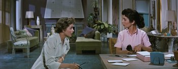 Movie still from “Three Coins in the Fountain” (1954), directed by Jean Negulesco – Two people sitting at a table talking to each other; Medium shot, Over the shoulder angle