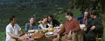Movie still from “Three Coins in the Fountain” (1954), directed by Jean Negulesco – A group of people sitting at a table with food; Wide shot, High angle