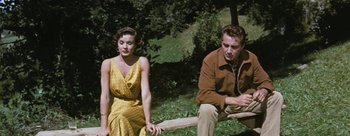 Movie still from “Three Coins in the Fountain” (1954), directed by Jean Negulesco – A man and a woman sitting next to each other on a bench; Medium shot, High angle