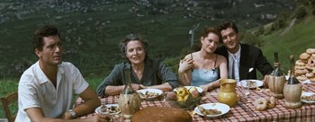 Movie still from “Three Coins in the Fountain” (1954), directed by Jean Negulesco – A group of people sitting at a table with plates of food on it; Medium shot, High angle