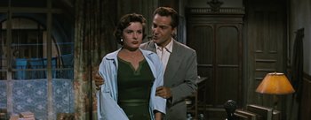 Movie still from “Three Coins in the Fountain” (1954), directed by Jean Negulesco – A man and a woman standing next to each other in a room; Medium shot, Low angle