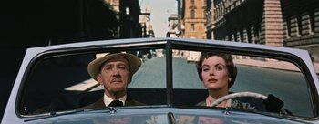 Movie still from “Three Coins in the Fountain” (1954), directed by Jean Negulesco – An older man and a younger woman in the back of a car; Medium shot, Over the shoulder angle