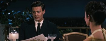 Movie still from “Three Coins in the Fountain” (1954), directed by Jean Negulesco – A man sitting at a table with a glass of wine; Medium shot, Over the shoulder angle