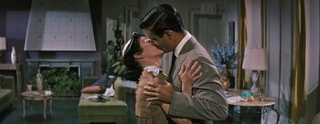 Movie still from “Three Coins in the Fountain” (1954), directed by Jean Negulesco – A man and a woman kissing each other in a room; Medium shot, Over the shoulder angle