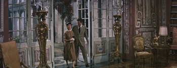 Movie still from “Three Coins in the Fountain” (1954), directed by Jean Negulesco – A man and a woman walking in front of a building; Wide shot, Low angle