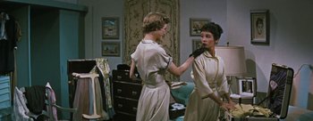 Movie still from “Three Coins in the Fountain” (1954), directed by Jean Negulesco – A woman is putting on lipstick in a dressing room; Medium shot, Low angle
