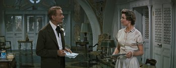 Movie still from “Three Coins in the Fountain” (1954), directed by Jean Negulesco – A man and a woman are talking in a living room; Medium shot, Over the shoulder angle