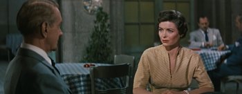 Movie still from “Three Coins in the Fountain” (1954), directed by Jean Negulesco – A woman sitting at a table in front of a window; Close Up shot, Over the shoulder angle