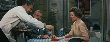 Movie still from “Three Coins in the Fountain” (1954), directed by Jean Negulesco – A man and a woman sitting at a dinner table; Medium shot, Over the shoulder angle