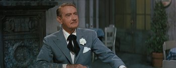 Movie still from “Three Coins in the Fountain” (1954), directed by Jean Negulesco – An older man wearing a suit and tie; Close Up shot, Over the shoulder angle