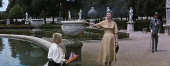 Movie still from “Three Coins in the Fountain” (1954), directed by Jean Negulesco – An older woman and a young boy in a park; Medium shot, Low angle