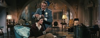 Movie still from “Three Coins in the Fountain” (1954), directed by Jean Negulesco – An old man and a young woman in a living room; Medium shot, Over the shoulder angle