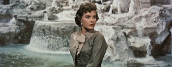 Movie still from “Three Coins in the Fountain” (1954), directed by Jean Negulesco – A woman standing in front of a waterfall; Close Up shot, Low angle