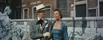 Movie still from “Three Coins in the Fountain” (1954), directed by Jean Negulesco – An older man and woman standing next to each other; Medium shot, Low angle