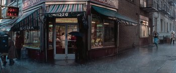 Movie still from “Three Days of the Condor” (1975), directed by Sydney Pollack – A person holding an umbrella in front of a store; Wide shot, High angle