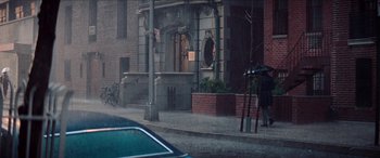 Movie still from “Three Days of the Condor” (1975), directed by Sydney Pollack – A man walking down the street holding an umbrella; Extreme Wide shot, High angle