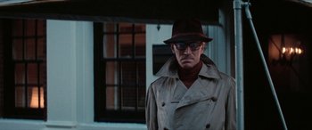 Movie still from “Three Days of the Condor” (1975), directed by Sydney Pollack – A man wearing a hat and a trench coat; Close Up shot, Low angle