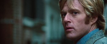 Movie still from “Three Days of the Condor” (1975), directed by Sydney Pollack – A man's face in a dark room; Close Up shot, Low angle
