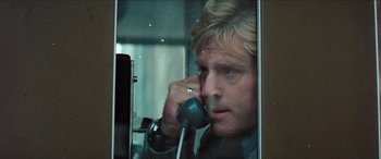 Movie still from “Three Days of the Condor” (1975), directed by Sydney Pollack – A person talking on a phone; Close Up shot, Low angle