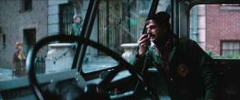 Movie still from “Three Days of the Condor” (1975), directed by Sydney Pollack – A man talking on a phone while sitting in a car; Medium shot, High angle