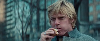 Movie still from “Three Days of the Condor” (1975), directed by Sydney Pollack – A person eating a donut; Close Up shot, Low angle