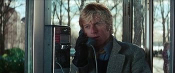 Movie still from “Three Days of the Condor” (1975), directed by Sydney Pollack – A man talking on a pay phone while wearing gloves; Close Up shot, Low angle