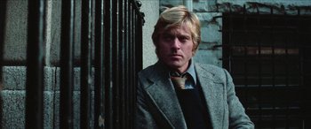 Movie still from “Three Days of the Condor” (1975), directed by Sydney Pollack – A person wearing a suit and tie; Close Up shot, Low angle