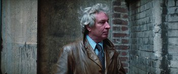 Movie still from “Three Days of the Condor” (1975), directed by Sydney Pollack – An older man in a leather jacket and a tie; Close Up shot, Over the shoulder angle